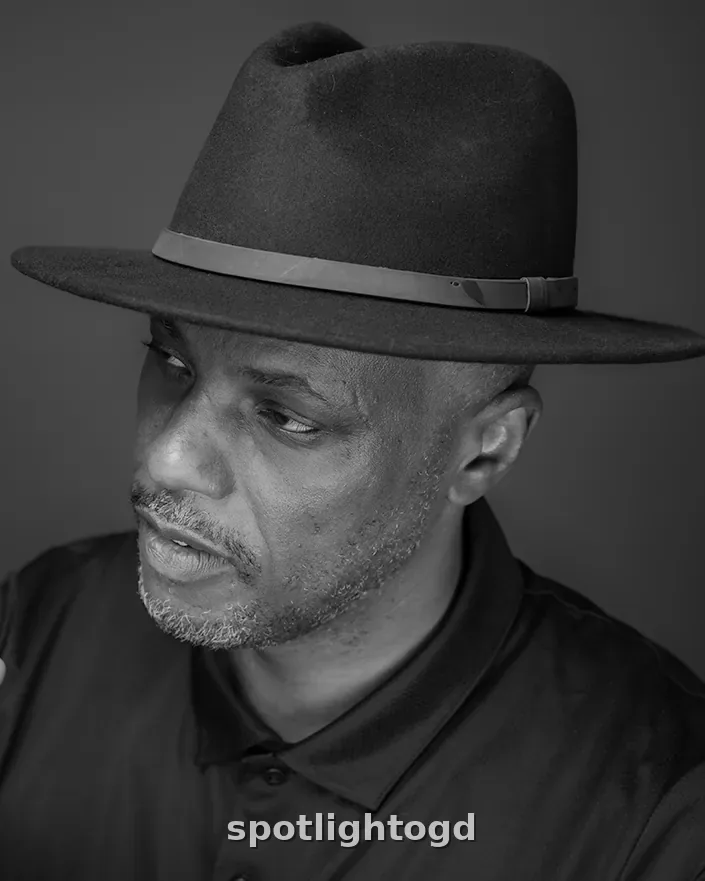 O.G. Dawodu in a black fedora, black and white portrait, looking to the side